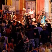 Photo de musiciens jouant devant un public de nuit